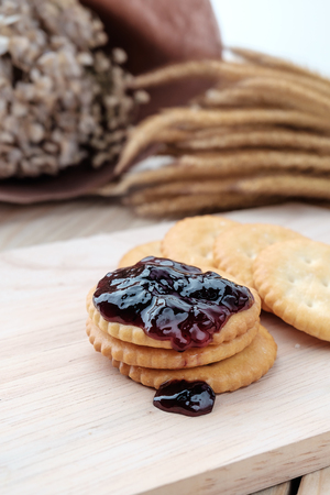 Cracker with jam on woodden backgroundの写真素材