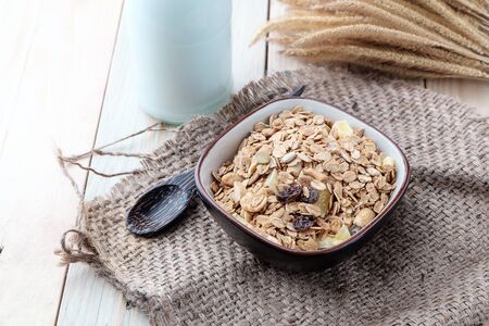 Breakfast cereals with dried fruits in a bowl on a wooden background.の写真素材