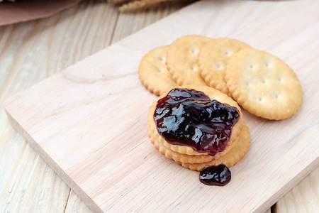 Cracker with jam on woodden backgroundの写真素材