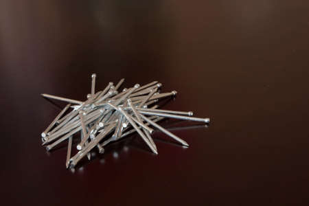 heap of nails on dark brow table topの写真素材