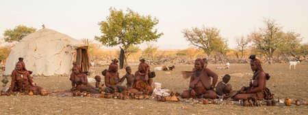KUNENE, NAMIBIA - SEPTEMBER 22, 2013: Himba women, accompanied by children, sit in blankets and display their wares to visitors.のeditorial素材