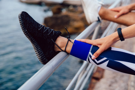 Close-up view of female leg while doing sports exercises during workout outdoors.