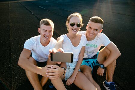Three happy best friends takig selfie.の写真素材