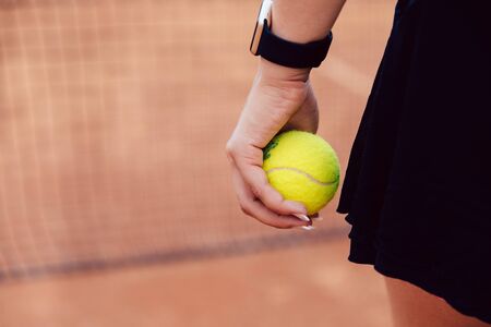 Woman holding tennis ball standing on the court. Close-up picture.の写真素材