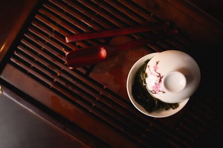Chinese tea ceremony. Porcelain white gaiwan on tea desk chaban. Top view.の写真素材