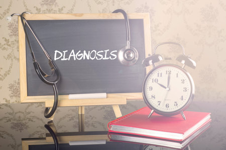 Diagnosis on blackboard with stethoscope and alarm clock.の写真素材