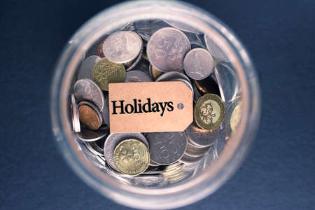 Saving Concept : Holidays label with coins in the glassの写真素材