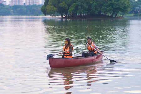 KUALA LUMPUR, MALAYSIA - SEPTEMBER 17, 2017:  Smiling young woman kayaking on a lake. Happy young woman canoeing in a lake on a summer day.のeditorial素材