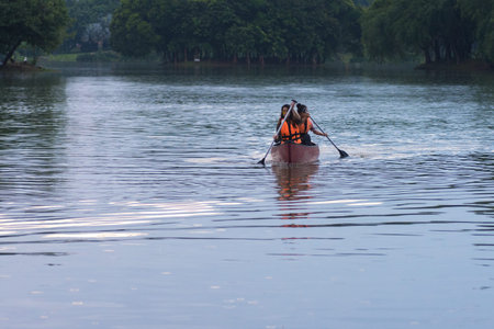 KUALA LUMPUR, MALAYSIA - SEPTEMBER 17, 2017:  Smiling young woman kayaking on a lake. Happy young...
