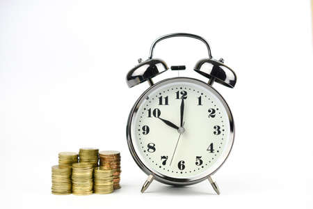 Alarm clock with stacking coins on white backgroundの写真素材