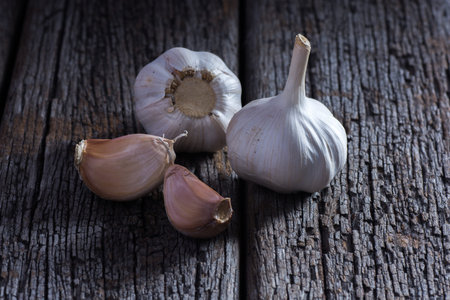 Organic garlic whole and cloves on the wooden background