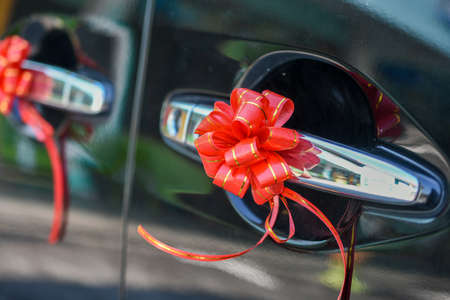 Wedding car of door decorated with red ribbon flowerの写真素材