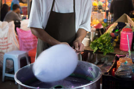 Hands of man spinning white cotton candyの写真素材
