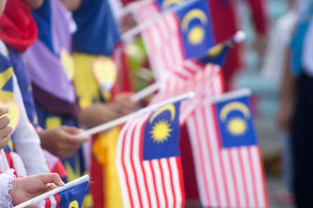 Hand waving Malaysia flag also known as Jalur Gemilang in conjunction with the Independence Day celebration or Merdeka Day.の写真素材