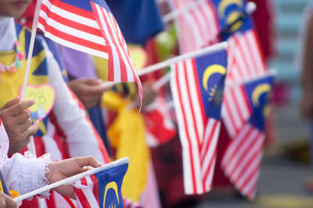 Hand waving Malaysia flag also known as Jalur Gemilang in conjunction with the Independence Day celebration or Merdeka Day.の写真素材