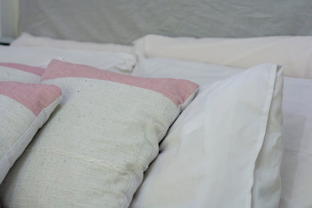 Closeup of new bed comforter with decorative pillows in staging model home