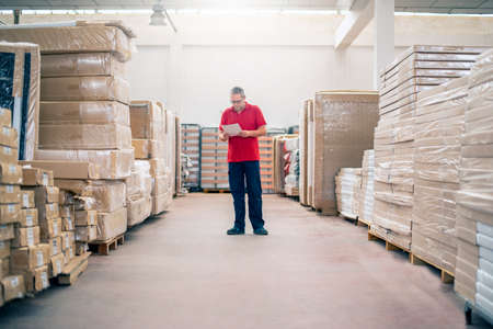 Warehouse employee checking the stock of stored productsの写真素材