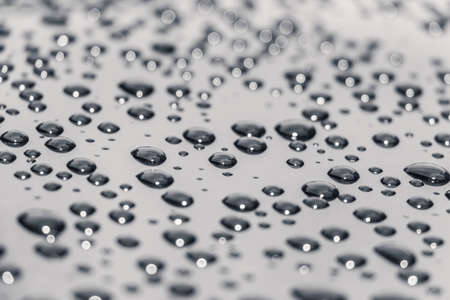 Liquid water drops after carwash. Many macro water drops reflecting in the sun lightの写真素材