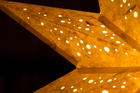 Orange golden star peaks on black background. Macro closeup of a shining star shape at christmasの写真素材