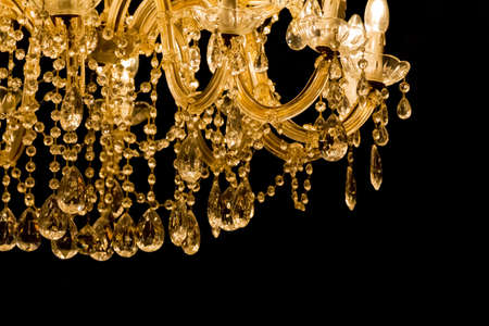 Luxury chandelier with light candles and right dark background. Noble candelabra hanging on ceiling with lots of little gems.の写真素材