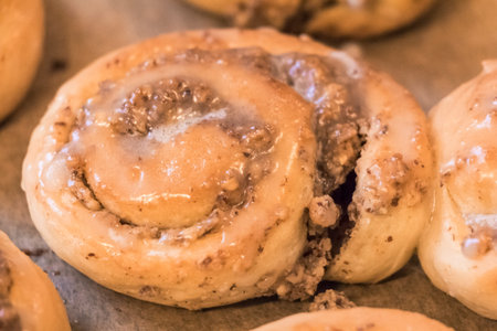 Tasty cinnamon rolls pastry with sugar frosting nuts stuffing. Delicious leavened dough pastries for breakfast, dessert or brunch. Yummy juicy backed traditional goods from bakery or confectionery.の写真素材