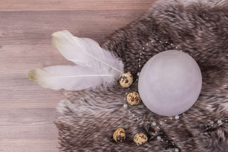 Easter holiday decoration design with eggs feathers on warm fur. Beautiful deco easternest with quail eggs, feather and big grey egg for celebration in april. Handmade tinker luxury tradition bouquetの写真素材