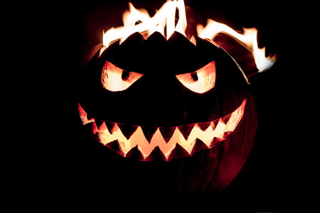 Carved spooky halloween pumpkin with glowing hot fire flame head. Big helloween autumn symbol with...