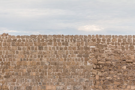 Old stable stone wall with rows of crafted masonry stones. Brickwork with individual craft bricks...