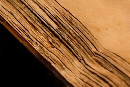 Ancient historic book of wisdom with golden parchment pages. Writing and reading knowledge in historic aged document from literature library. Yellowed antique sheets with history content inside.の写真素材