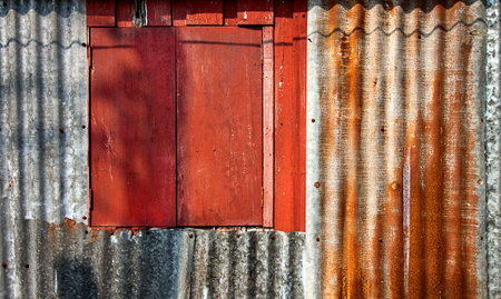 Red wooden window on old zinc wall.