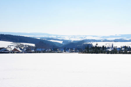snowy HunsrÃ¼ck with the Dhrontal and the village Heinzerath in the foregroundの写真素材