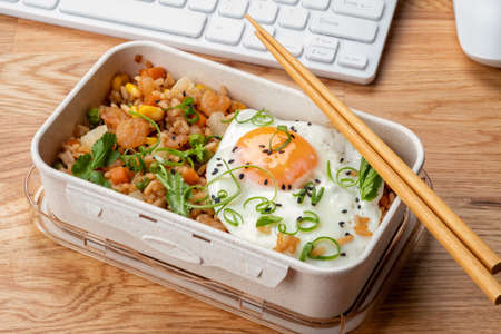 Shrimp fried rice with vegetables and egg in a lunch boxの写真素材