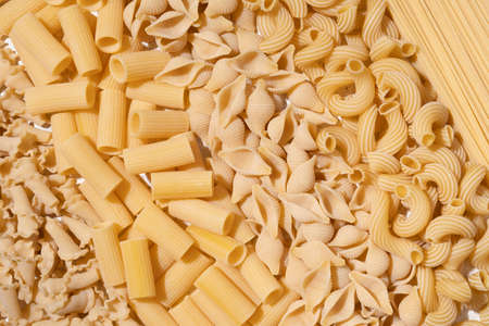 Different types of raw pasta on a textile backgroundの写真素材