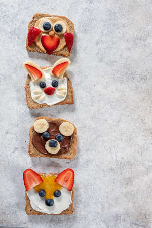 Funny animal faces toasts with spreads, butters, banana, strawberry and blueberryの写真素材