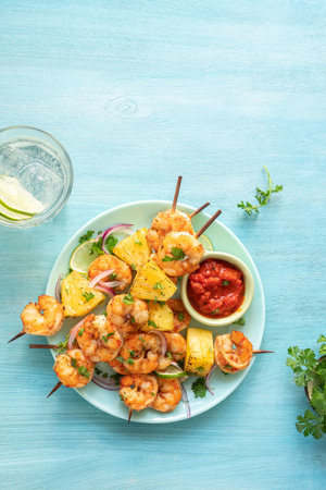 skewers of barbecued shrimp with a pineappleの写真素材