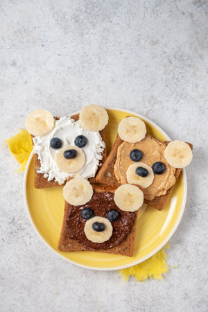 Breakfast toasts with nut butter and banana with cute funny bear faceの写真素材