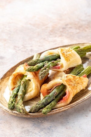 Baked green asparagus with ham and cheese in puff pastryの写真素材
