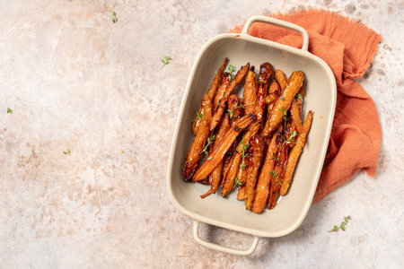 Roasted carrots with thyme, garlic, lemon and honey on baking trayの写真素材