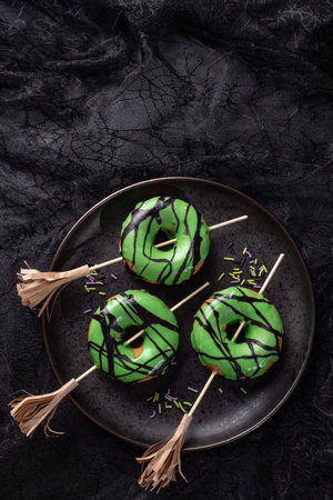 Halloween donut with green glaze and witchs broom. Trick or treat.の写真素材