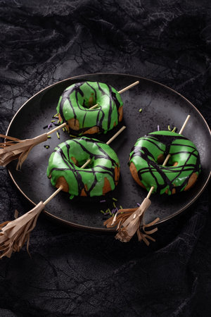 Halloween donut with green glaze and witchs broom. Trick or treat.の写真素材