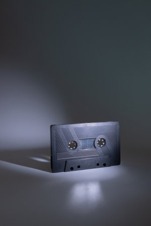 Audio cassette blurred on dark grey background with spot of light on it. Analog Audio Tape.の写真素材
