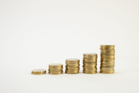 Golden Euro Coins stacked on a white background. Money coins saving concept side view. Copy space.