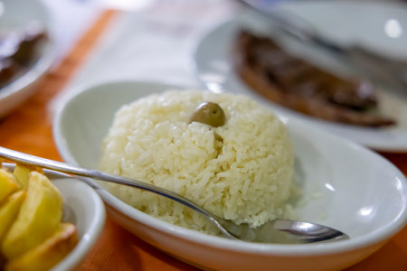 Rice with a green olive on the table. Closeup. Selective focus.の写真素材