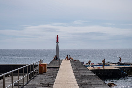 Caloura, Azores, 19.09.2019 - View over the pier and small lighthouse in Caloura Fishing Port on the island of Sao Miguel in the Azoresのeditorial素材