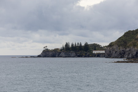 View to Caloura bay with buildings and a background with a cloudy sky. São Miguel island, Azores.の写真素材