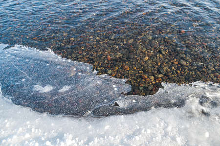 winter came and the banks of the river began to be covered with iceの写真素材