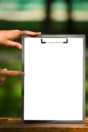 The white sheet of paper on the clipboard and handsの写真素材