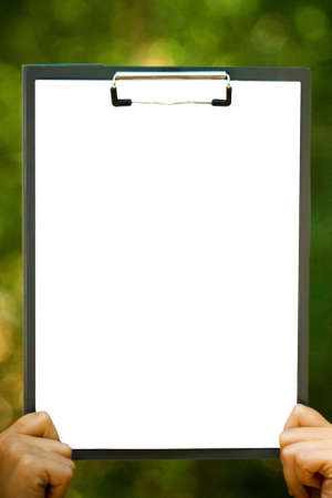 The white sheet of paper on the clipboard in handsの写真素材