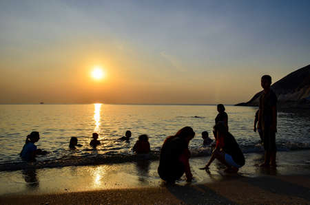 Sunrise on the beach and swimming in silhouetteの写真素材