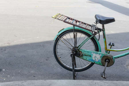 Old green bicycle parked roadside Thailand.の写真素材